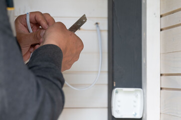 Stripping electrical wires and installing switches in a gazebo in the garden.
