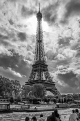Tourists admire the Eiffel Tower from a boat cruising on the Seine River, Paris, France, in black and white