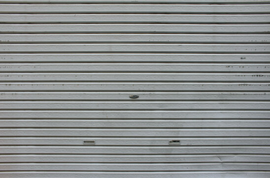 Metal roll up door. Gray roller shutter. Steel sliding door texture. Metal store door background.	