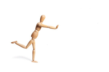 A wooden mannequin doing exercises on white background with copy space