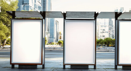 Vertical blank white posters at a bus stop in an urban setting showcasing sleek and modern design