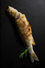 Grilled sea bass with rosemary on black stone