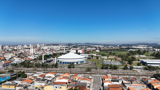 Imagem a&eacute;rea da Arena Max Feffer em Suzano, SP. Estrutura esportiva cercada por vegeta&ccedil;&atilde;o urbana, captada por drone em dia de sol. Suzano SP em 10 Julho 25