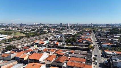 Drone mostra a cidade de Suzano no Alto Tiet&ecirc;, destacando o crescimento urbano, &aacute;reas residenciais e comerciais com ruas bem tra&ccedil;adas e vegeta&ccedil;&atilde;o ao redor