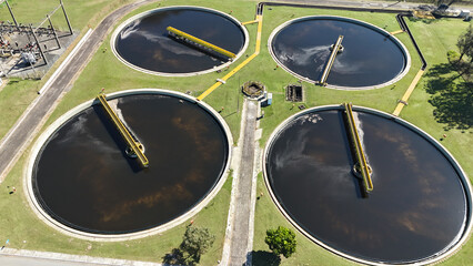 Visão aérea dos tanques circulares de decantação utilizados no processo de tratamento de esgoto em uma estação industrial de saneamento