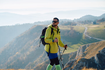 An extreme mountaineer, equipped with professional gear, pushes towards the peak of the mountain at...