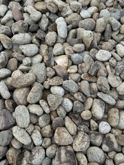 background of stone wall Close-up view of smooth gray river stones arranged closely together, showing natural texture and pattern.