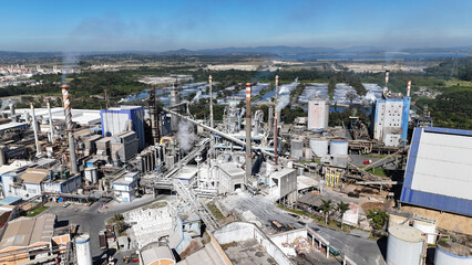 Aerial view of a paper and pulp industry with polluting chimneys and steam emissions, highlighting...