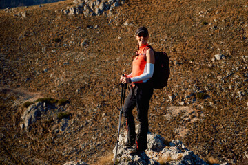 A female mountaineer, equipped with professional gear, enjoys the thrill of her climb as she...