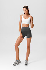 Fitness woman. Athletic girl on the gray background