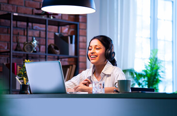 Indian professional attends virtual session on laptop while sitting at work desk in office