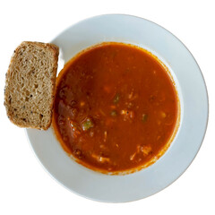 Red tomato soup with bread on white plate