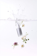 Botella cosmética blanca con flores y agua en fondo minimalista, envase de sérum para skincare con diseño limpio y elegante, mockup de frasco cosmético flotando en agua con flores blancas