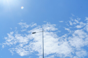 Street lamp under blue sky, white clouds and sunshine