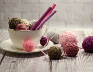 A cup and a saucer with clews balls of yarn wool and crocheted blanket handmade craft bright photo	
