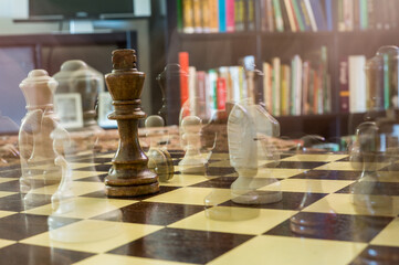 Chess board with a black King and the rest of the pieces in ghost effect around it