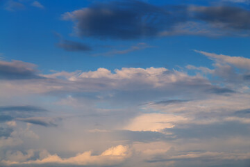 Evening sky before twilight with delicate clouds in creamy pastel tones above the horizon, a...