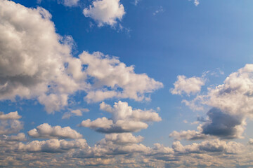 Bright white clouds against the backdrop of a blue summer sky, panoramic view of the sky with white...