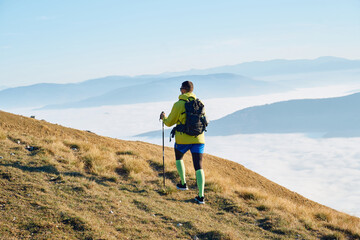 An extreme mountaineer, equipped with professional gear, pushes towards the peak of the mountain at...