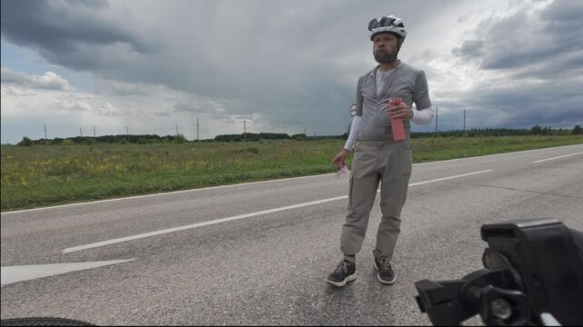 cycling in nature in wild places, bike-packing. A cyclist eats lunch on the road