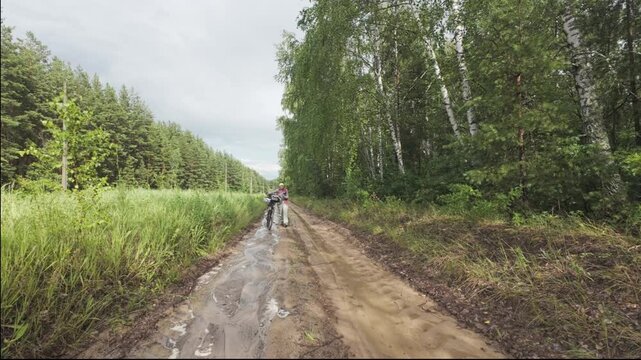 cycling in nature in wild places, bike-packing. Riding in the forest in the rain
