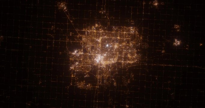 Lincoln (Nebraska, USA) aerial view at night. Top view on modern city with street lights. Camera is zooming out, rotating clockwise. Vertical video. The north is on the left side