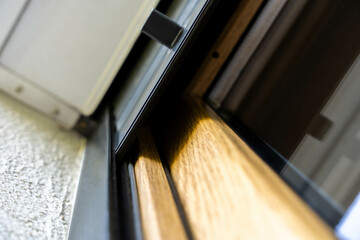 Detailed view of dark ray anti-burglary roller blinds and wooden window frame. low angle outdoor...