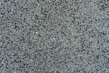 Macro photo of granite surface texture with visible pebbles and mineral grains, ideal for backgrounds, materials, or surface design contexts