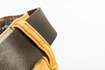Close-up of brown pants with textured fabric and dark brown leather belt in minimal studio light, fashion detail and clothing design