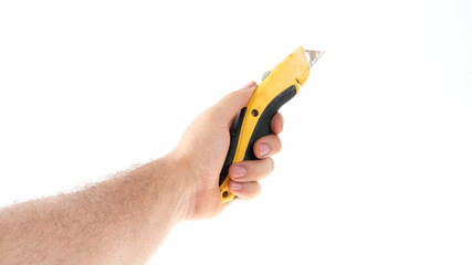 Hand with utility knife on white bg