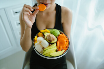 A woman enjoys a fresh, healthy salad made with organic vegetables at home, promoting a balanced...