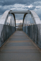 Fototapeta premium Arched Metal Bridge in an Industrial Area on a Cloudy Day