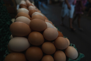 A frame full of chicken eggs in a cardboard box for sale at a market.