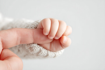 Close-Up of Baby Holding Parent’s Finger on White Background