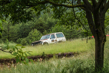 old, abandoned SUV car left behind in a nature area in France