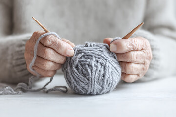 Close-Up of Elderly Hands Knitting with Soft Yarn