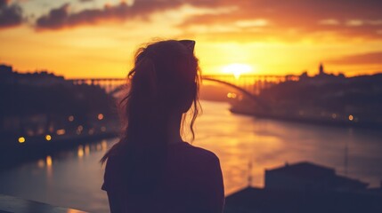 woman silhouetted against stunning sunset cityscape