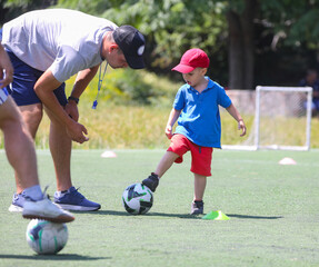 Coach with little  boys learning in football school
