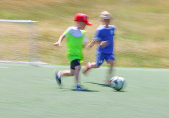 little  teens  boys plays football at a sports school .Blur.