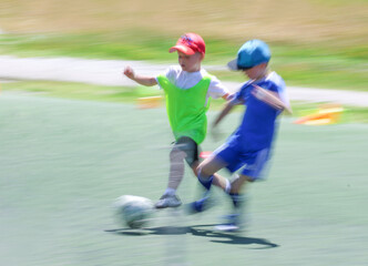 little  teens  boys plays football at a sports school .Blur.