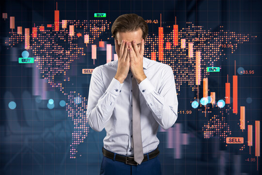 Businessman facepalming in stress amid global financial crisis with falling stock charts and world map in corporate office background.