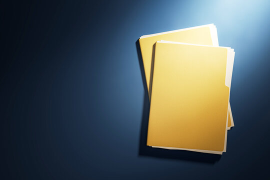 Two yellow document folders on dark blue desk under spotlight, top view mockup for business template or report cover in office workspace. 3D Rendering