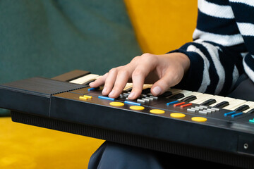 Close-up of a musician's hand adjusting the settings on a vintage synthesizer keyboard, exploring...