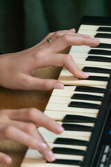 Fingers dancing effortlessly over the keys of an electronic keyboard, creating a captivating melody...