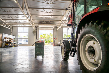 Tractor maintenance service garage with modern tools and industrial equipment inside spacious...