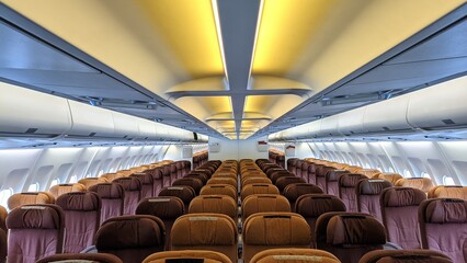 Interior view of airplane cabin with passenger seats in a row