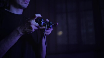 An immersed and focused mood is captured by a close-up of hands expertly manipulating a video game controller, dimly lit by a blue glow, suggesting intense gameplay in a dark room