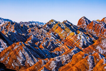 Amazing scenery of Rainbow mountain and blue sky background in sunset. Zhangye Danxia National Geopark, Gansu, China. Colorful landscape, rainbow hills, unusual colored rocks, sandstone erosion