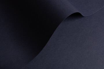 Navy blue paper texture with abstract wave folds. Minimalistic design, chic and trendy fashion style