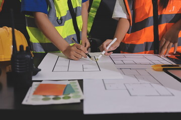Closeup of team of industrial engineers meeting analyze machinery blueprints consult project on...